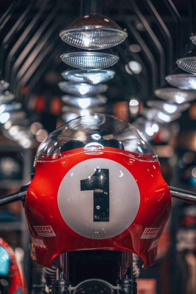 Close-up of a vintage racing motorcycle at an indoor exhibition showcasing classic motorbikes.