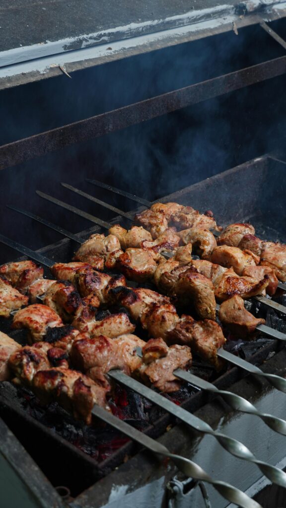 Juicy chicken skewers grilling over hot coals with smoke rising, perfect summer barbecue.