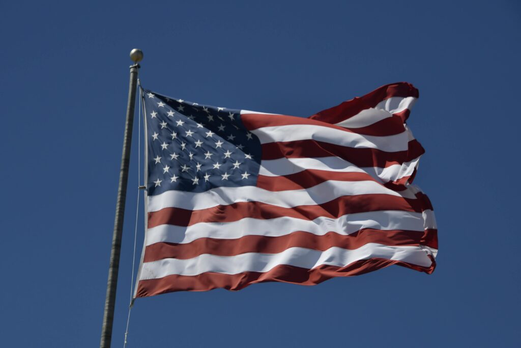 A classic view of the United States flag waving against a clear blue sky, symbolizing patriotism.