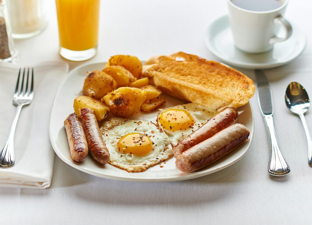 A hearty full English breakfast with eggs, sausages, potatoes, and toast.