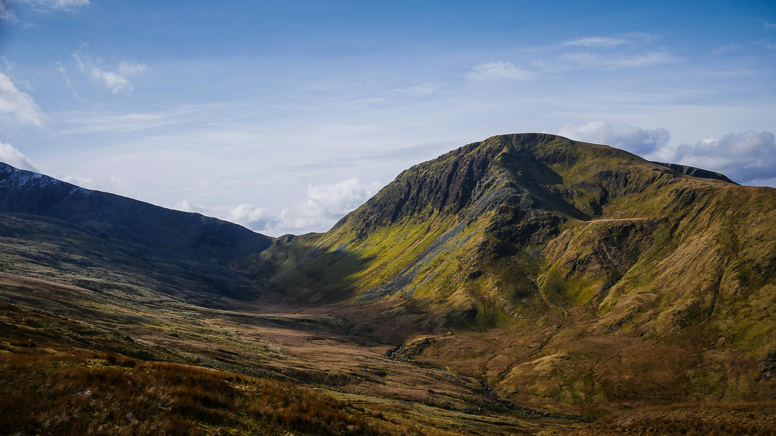 Majestic mountain landscape in Snowdonia, Wales, under a vibrant sky.