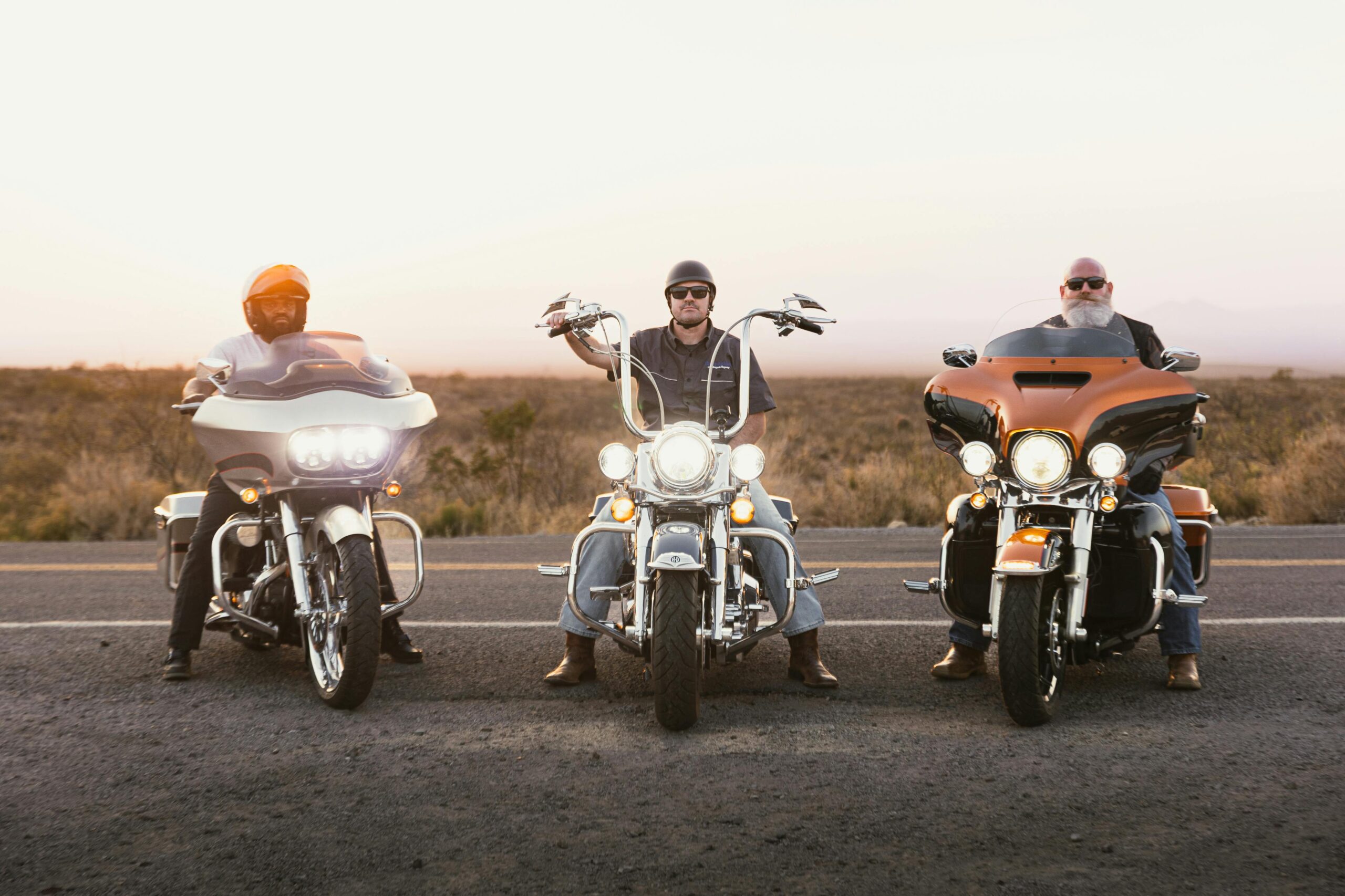 Three bikers on motorcycles on Route 66 in New Mexico at sunset, capturing freedom and adventure.