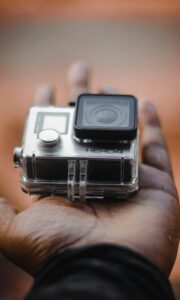 Close-up of a GoPro action camera held in a hand, showcasing portable video technology.